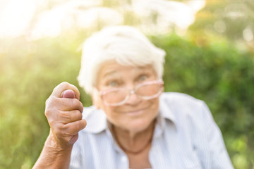 Old woman shows hand gestures Fig