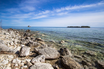 Les Cheneaux Islands In Lake Huron. Sunny day on the rocky coast of Lake Huron with the Les Cheneaux Islands at the horizon. The islanders are a popular destination for kayakers.