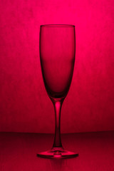 An empty transparent glass on pink background