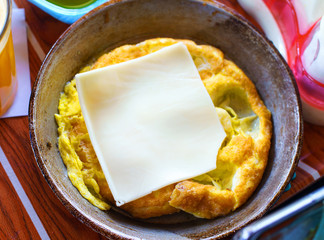 Fried eggs in the frying pan with cheese at home. Top view.