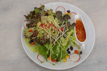 Salad Recipe in a white dish on the table background.