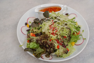 Salad Recipe in a white dish on the table background.