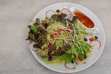 Salad Recipe in a white dish on the table background.