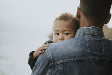 Father holding his child resting outdoors © Rawpixel.com
