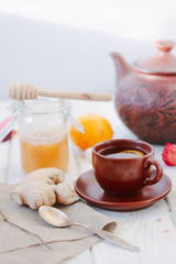 Ginger tea with lemon, lime and honey on white.