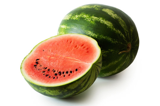 Half watermelon with seeds next to whole watermelon isolated on white.