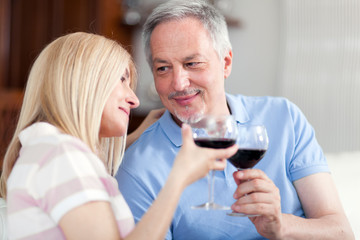 Mature couple toasting wine glasses