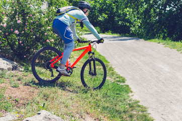 Cyclist on an orange bike riding a bicycle path