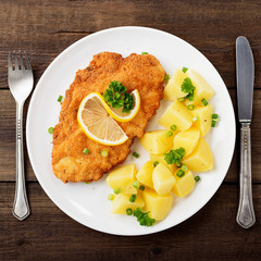Homemade breaded german weiner schnitzel with potatoes. top view