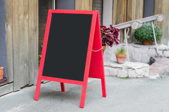 Wooden red restaurant signboard with place for text on the street