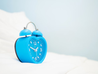 The vintage metal alarm clock on  the bedroom shows time in hour