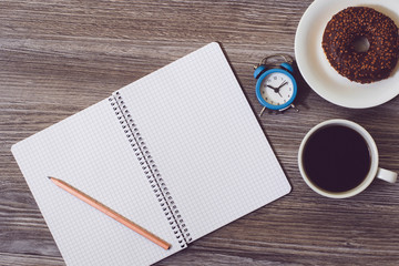 notebook and cup of coffee on wooden table