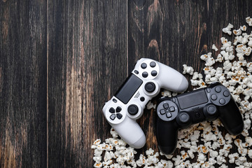 gamepad and popcorn on a wooden background © solidmaks
