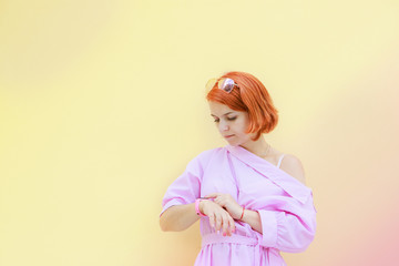 cute redhead girl looking at her watch and waiting for someone late waiting