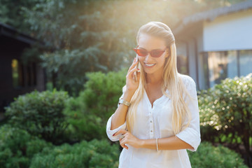 Mobile communication. Positive joyful woman smiling while having a phone conversation