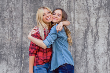 Emotion expressing summer punk holiday  vacation positive celebrate success toothy smile concept. Two beautiful cheerful excited girls wearing checkered shirt hugging isolated on concrete background