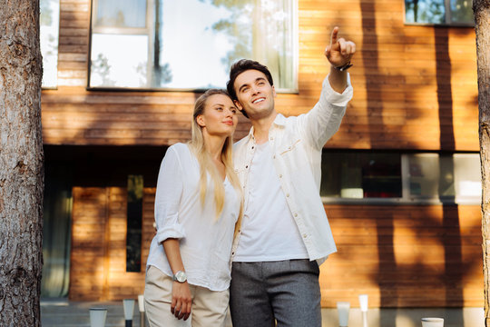 Pleasant communication. Delighted nice couple talking to each other while standing near their house