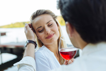 Absolutely happy. Nice positive woman closing her eyes from happiness while being together with her boyfriend