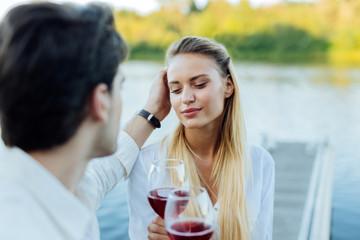 Caring boyfriend. Nice caring man touching his girlfriends hair while expressing his love to her