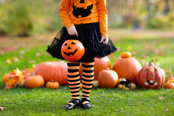 Obraz premium Kids with pumpkins in Halloween costumes