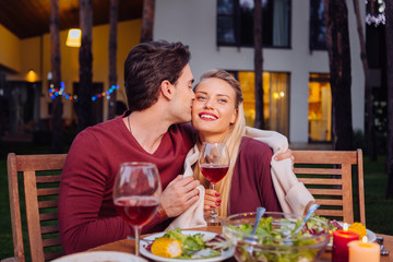 My feelings. Nice young man kissing his girlfriend in the restaurant while expressing his feelings to her