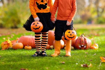 Kids with pumpkins in Halloween costumes