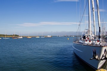 Bow of Yacht Moored with Smaller Sailboats in Background