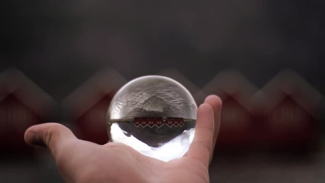 Man holding a crystal ball looking at house