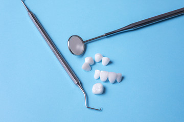 Dental tools and zircon dentures on a blue background - Ceramic veneers - lumineers