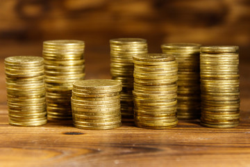 Stacks of golden coins on wooden background