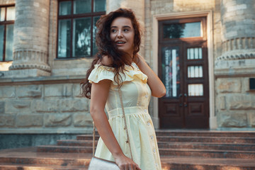 Smiling woman looking away over the shoulder while walking outdo