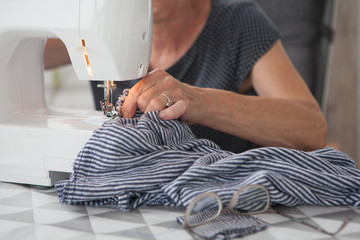 Woman using Sewing Machine. Seamstress at Work.