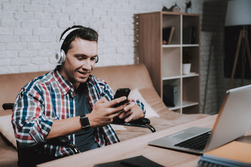 Young Disabled Man on Wheelchair Working at Home.
