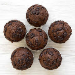 Chocolate muffins on white wooden background, top view. Flat lay, overhead, from above. Closeup.