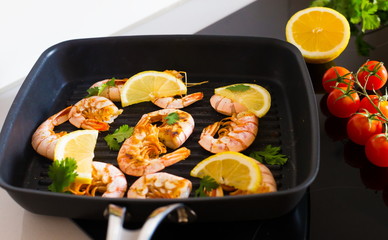 Food. Langoustines, induction stove, vegetables, grill pan