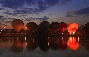Fototapeta premium Hot air baloons flying in the evening sky near the lake