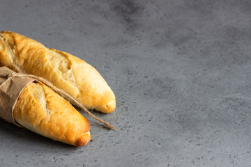 Fresh baguette on a grey concrete background. Bread. Top view. Copy space for text.
