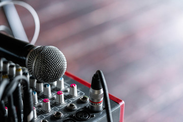 A wireless microphone close-up lies on the mixing console. empty space
