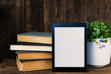 Ebook, digital tablet device, with old real books nearby