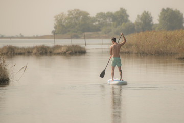 Fototapeta na wymiar Man stand up paddleboarding