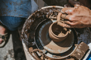 Master hands makes a pot of clay. Master class is held in nature, close-up