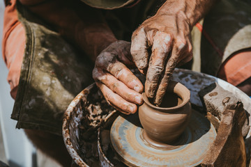 Master hands makes a pot of clay. Master class is held in nature, close-up