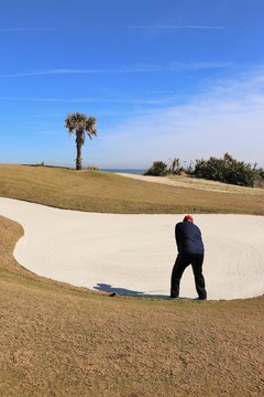 Golf course greens and golfer in a tropical setting