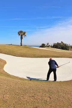Golf course greens and golfer in a tropical setting
