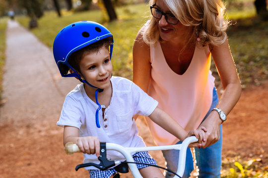 Happy Boy Driving A Bike With Her Mom