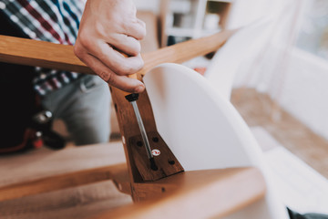 Young Man Assembling Coffee Table and Stools.