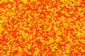 Orange and yellow candy sprinkles macro background