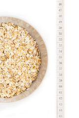 Oatmeal in white plate and centimeter on white background