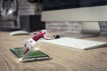 Football Player with a red uniform playing and coming out of a full screen phone on a wooden table.