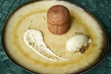 Fondant cake dessert and pistachio ice cream with English cream, pistachio crumble and sauce bailies